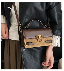 Detail of vintage brown quilted stitching handbag with metal lock and chain strap