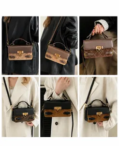 Close-up of retro color-block handbag with matte leather and metal chain detail