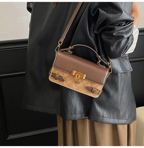 Detail of vintage quilted baguette bag with gold U-lock and chain strap on model