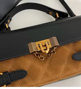 Detail of the vintage gold clasp on a quilted leather handbag with texture contrast