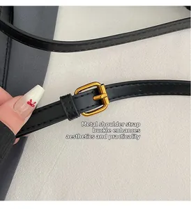 Detail of adjustable black leather strap with gold metal buckle for luxury handbag