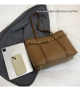 Brown tote bag size comparison with tablet and phone on white cloth background