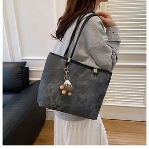 Grand sac cabas noir à motif marbre avec pendentif ours en peluche porté à l'épaule