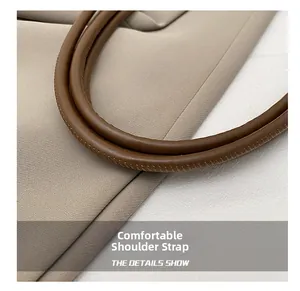 Détail de la bandoulière en cuir marron avec surpiqûres fines sur le sac