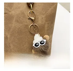 Gros plan d'un charme en peluche marron avec lunettes et bonnet sur un sac cabas en cuir