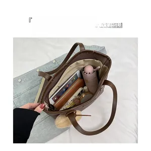 Macro view of large brown leather tote bag interior with organized storage compartments
