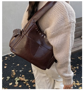 Detail of dark brown oil wax leather shoulder bag with vintage silver rivet studs