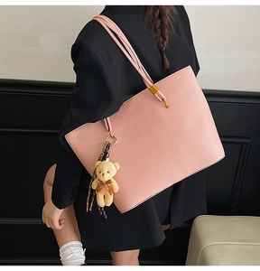Pink lychee texture tote bag detail showing shoulder strap and cute bear charm pendant