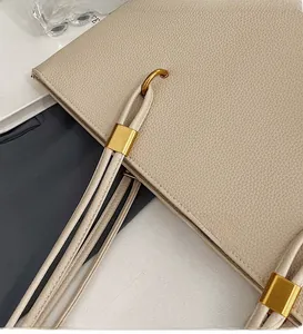 Macro detail of luxury lychee grain leather handbag with shiny gold hardware accents