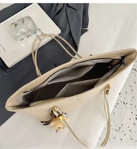 Interior view of beige tote bag showing multiple compartments and textured lychee leather