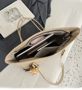 Interior view of large beige tote bag holding a tablet and daily essentials with teddy charm