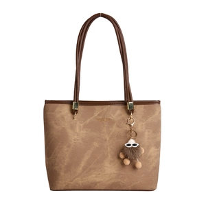 Grand sac cabas marron avec longues anses et breloque en peluche sur fond blanc