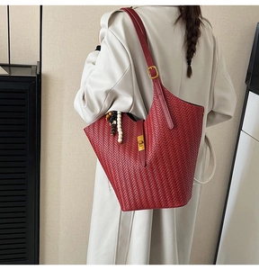 Détail du grand sac cabas en cuir tressé rouge avec pompon de perles et fermoir doré