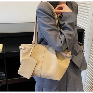 Detailed macro view of beige suede tote bag texture with minimalist side buckle strap