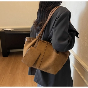 Close-up of brown suede tote bag with matching zippered pouch and side strap detail