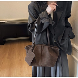 Brown suede tote bag detail with matching detachable square pouch on a soft silhouette
