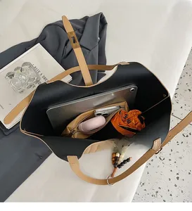 Vue de dessus du grand sac cabas en cuir kaki avec pochette intérieure et accessoires