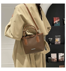 Brown litchi texture leather tote bag shown on model in a stylish urban setting