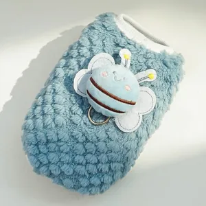 Macro detail of blue fleece dog vest with soft honeybee toy and metal D-ring attachment