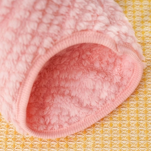 Close-up of soft pink sherpa fleece fabric and elastic ribbed hem on dog clothes