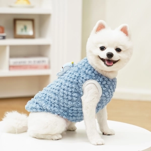 Detail of soft blue fleece pet vest with small ornament worn by a Pomeranian dog