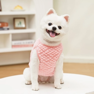 Detail of pink fleece pet vest showing soft textured fabric on a Pomeranian