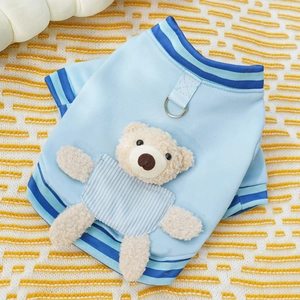 Macro detail of blue knit dog vest with a teddy bear patch and metal D-ring attachment