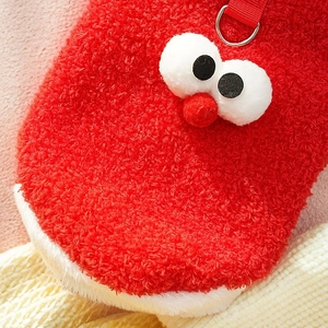 Detail of red plush pet outfit with cartoon eyes, soft festive material and D-ring hook
