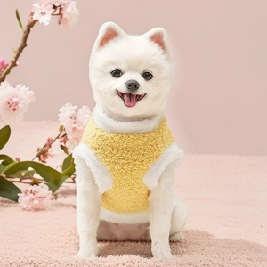 Close-up of yellow plush pet vest with white fleece trim for small dogs or cats