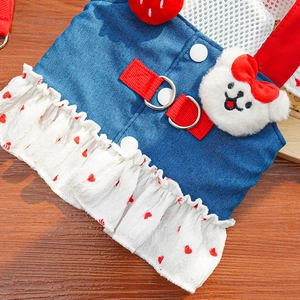Detail van blauwe denim hondentuigje met rode hartjesruches en schattige pluche beer decor
