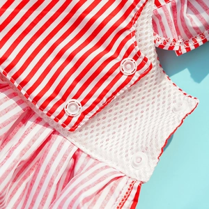 Close-up of red striped pet dress showing breathable mesh lining and snap buttons