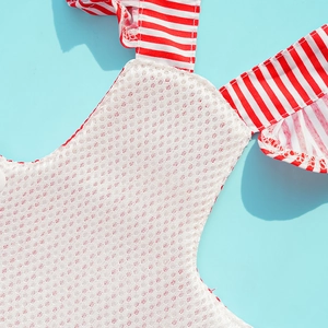 Detailed close-up of white breathable mesh fabric and red striped trim on pet dress