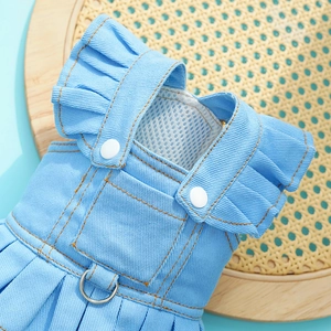 Detail of light blue denim pet dress featuring ruffles, snap buttons and metal D-ring