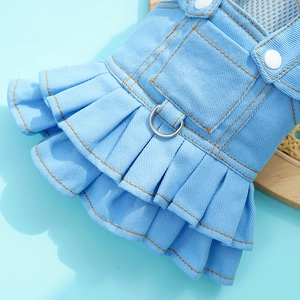 Detail of blue denim pet dress showing metal D-ring and dual pleated skirt design