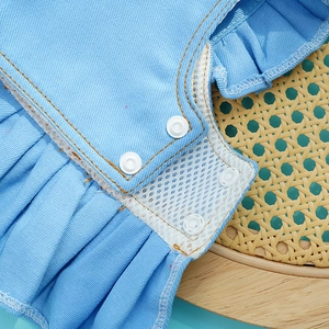 Close-up of denim pet dress with white mesh trim and snap button closure detail