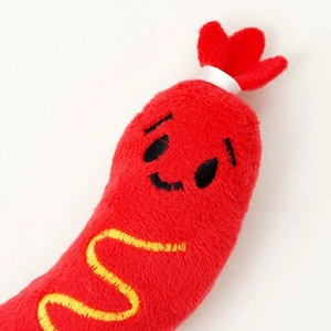 Vue macro d'un jouet pour chat en forme de hot-dog avec broderie jaune et peluche douce
