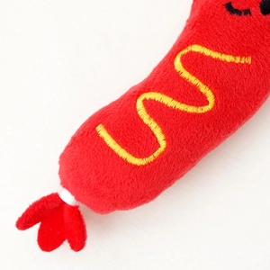 Détail macro du jouet en peluche pour chien avec tissu rouge et broderie jaune