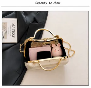 Detail view of the elegant gold box evening bag showing spacious interior capacity