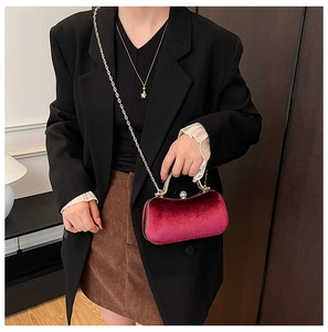 Detail of luxury burgundy velvet evening box bag with gold metal handle and chain strap