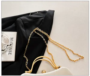 Detail of elegant white velvet evening bag with gold chain and diamond spherical clasp