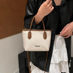 Sac seau minimaliste beige et marron pour femme avec logo métallique et bandoulière amovible