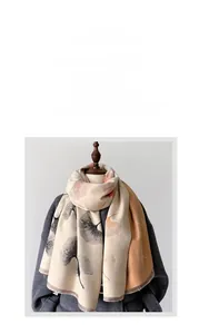 Detail of warm beige shawl featuring orange ginkgo leaf prints and fine fringe tassels