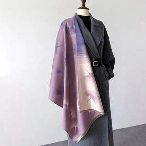 Detail of elegant purple and beige leaf pattern shawl with fringe on a gray coat