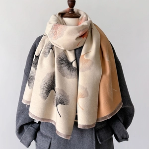Detail of leaf pattern pashmina shawl featuring warm beige tones and delicate fringe