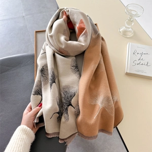 Detail of leaf print scarf with tassels, thick knit texture for autumn and winter warmth