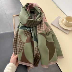 Détail d'une écharpe en cachemire avec motifs patchwork colorés et finitions franges