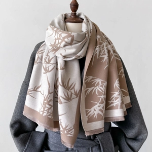 Macro detail of the bamboo leaf print texture and soft fringes on the latte scarf