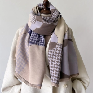 Détail d'un châle à carreaux doux avec motifs géométriques et ourlet à franges