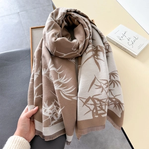 Detail of bamboo leaf jacquard pattern on a cozy earth-tone scarf with soft fringes