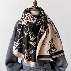 Vintage bamboo leaf print long scarf with tassels for winter on a grey mannequin
